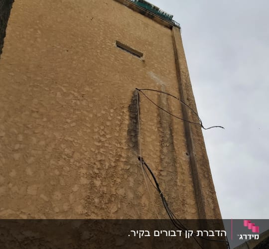 קיר בניין עם חוטים חשופים ופתחים